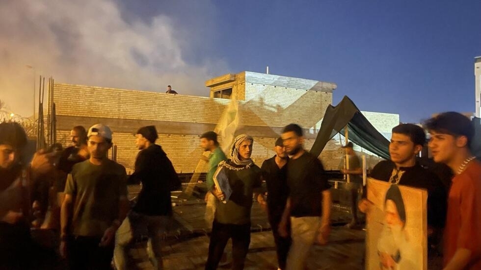 Protesters stand on top of a building next to the Swedish embassy in Baghdad, Iraq on July 20, 2023. 